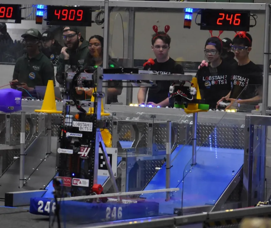 Driver George '24 and operator Maxwell '25 placing a cone on the high node during one of our qualification matches.