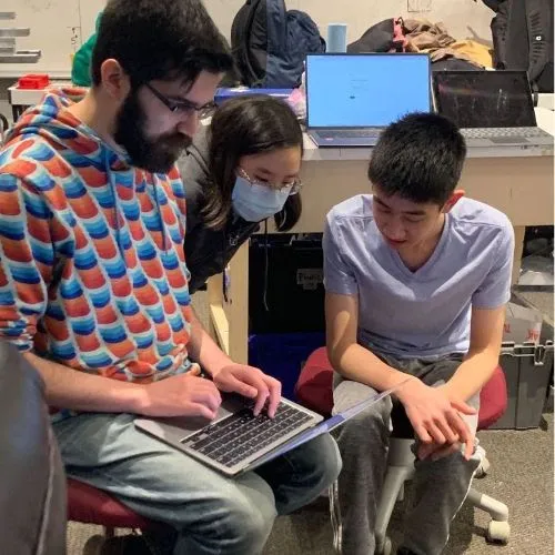Sam (Mentor) helping students Kendree '25 and Maxwell '25 set up cameras for testing on our old robot.