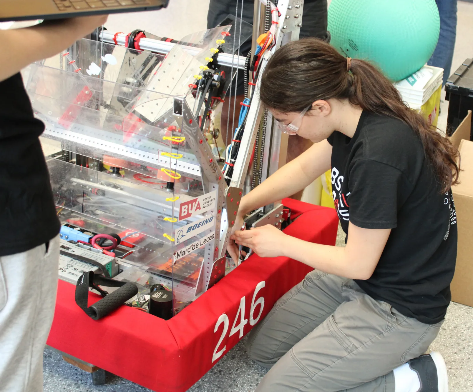Eliana Mirkis (’28) works on the robot in the pits.